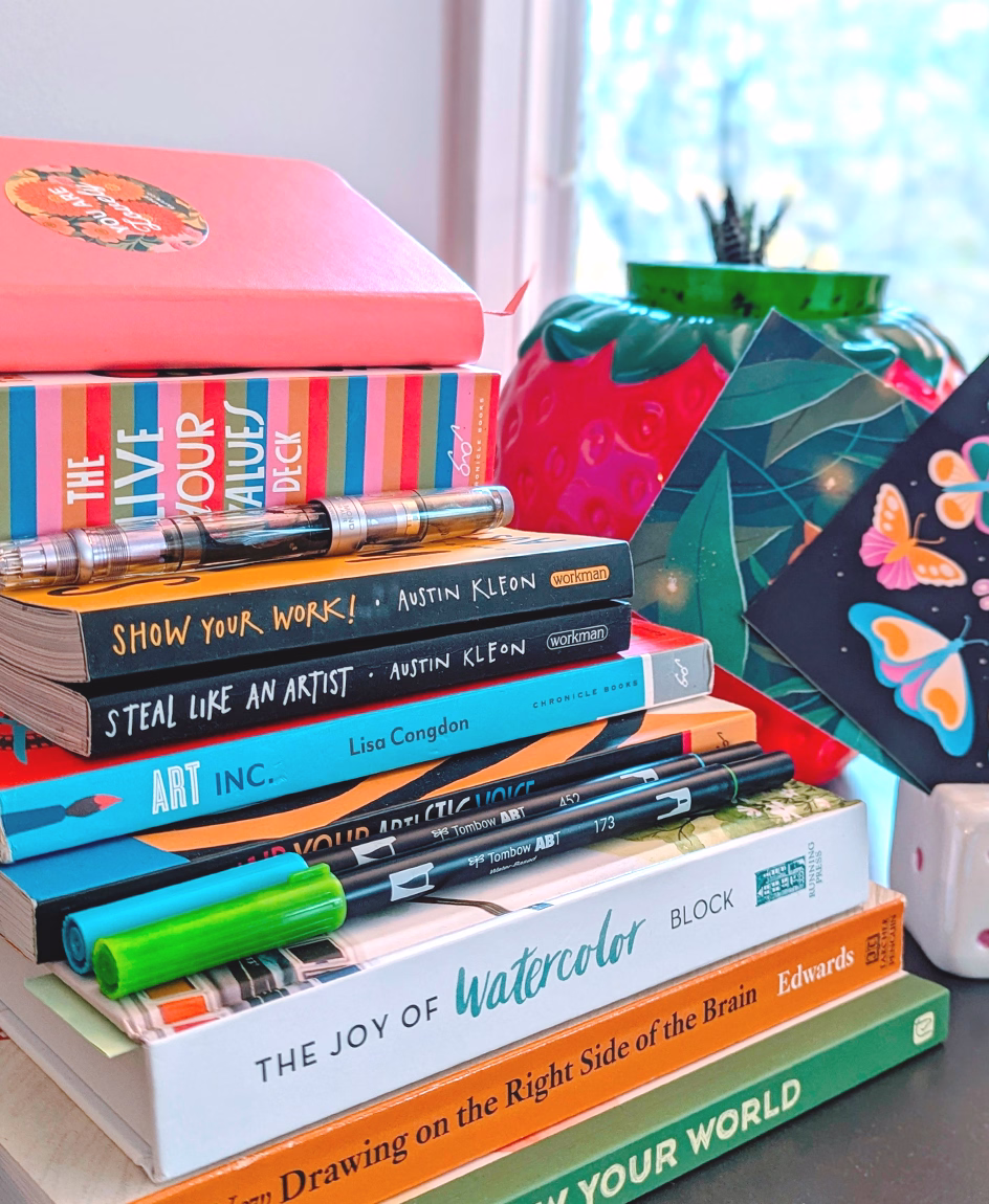 Stack of colourful art and design books in Tawn Moore’s illustration studio